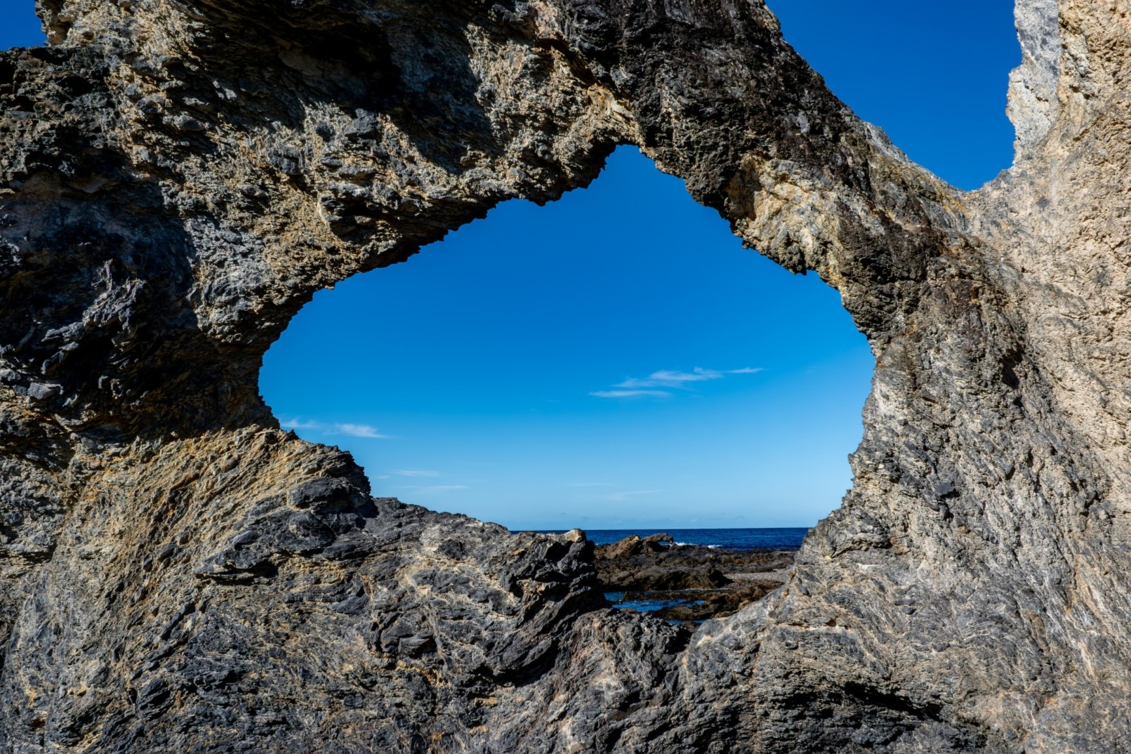 A view of the ocean through eroded rock