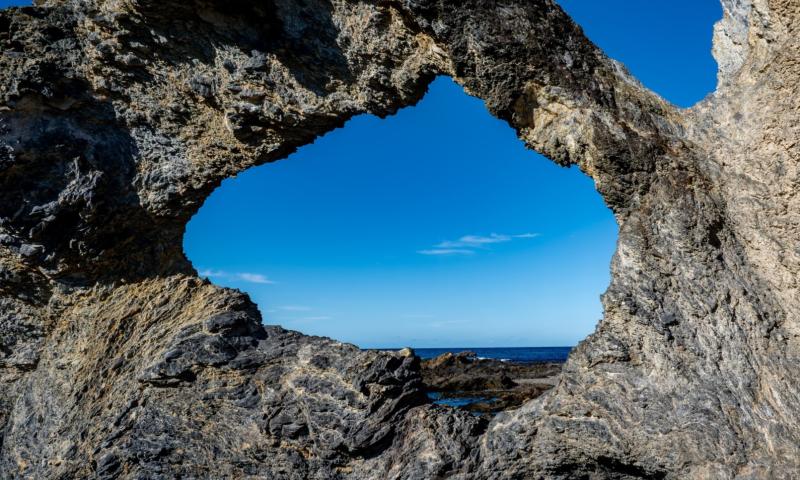 A view of the ocean through eroded rock